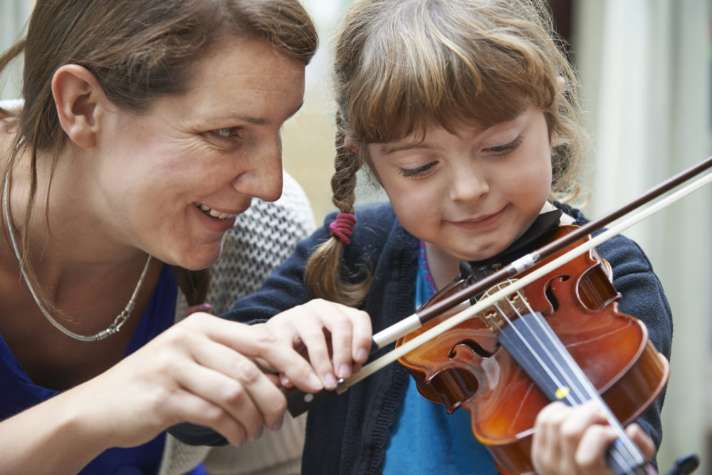 Woman teaches girl violin